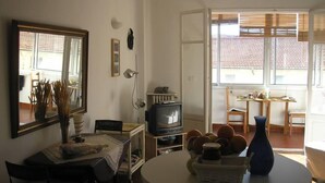 A living room with a round table, a television, and a dining area with a table and chairs. - FESTIVAL SEA CLASS & CHARME CANNES MONTFLEURY (Cannes)