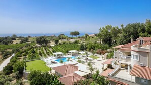 Una villa con piscina, giardino e vista sul mare.