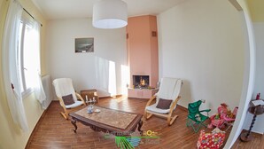 A spacious living room with a fireplace, two armchairs, a coffee table, and a view of the outdoors. - Agriturismo da Rosi - Marina house with swimming pool (Codevigo)