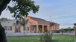A two-story building with a tiled roof, a covered patio area, and a well-maintained lawn. - Agriturismo da Rosi - Marina house with swimming pool (Codevigo)