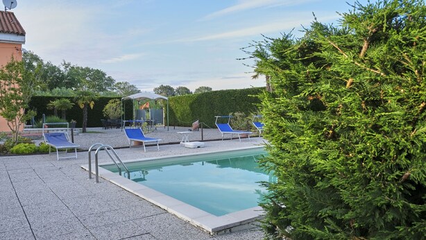 A swimming pool with blue lounge chairs and a covered seating area. - Agriturismo da Rosi - Marina house with swimming pool (Codevigo)