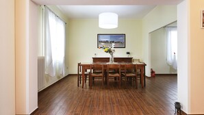 A dining area with a wooden table and chairs, a hanging light fixture, and a framed picture on the wall. - Agriturismo da Rosi - Marina house with swimming pool (Codevigo)
