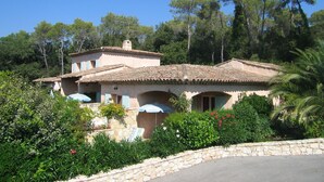 A Mediterranean-style villa with a tiled roof, stone walls, and a stone pathway leading to the entrance. - In villa, charming studio 2 pers with terrace in St Paul de Vence (Saint-Paul-De-Vence)