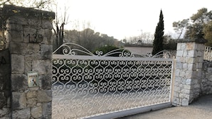 Eine Steinsäule mit der Nummer 139, ein schmiedeeisernes Tor und eine Steismauer.