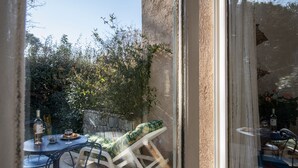 Eine Terrasse mit Tisch, Stühlen und einer gepolsterten Sitzecke.