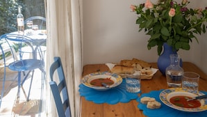 Ein Esstisch mit zwei Suppenschüsseln, einer Blumenvase und einer Weinflasche.