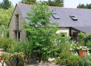 Un bâtiment en pierre doté d’un toit en pente et d’une petite lucarne.