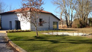 Un bâtiment d’un seul étage, avec un toit recouvert de tuiles rouges, un petit porche à l’avant et une pelouse bien entretenue.