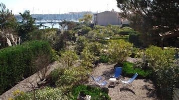 Relax in a serene outdoor space surrounded by lush greenery and a tranquil marina view.