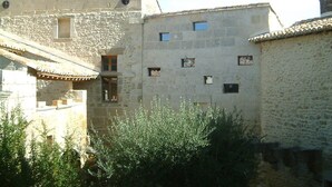 Un bâtiment en pierre doté de nombreuses petites fenêtres et d’un toit recouvert de tuiles.