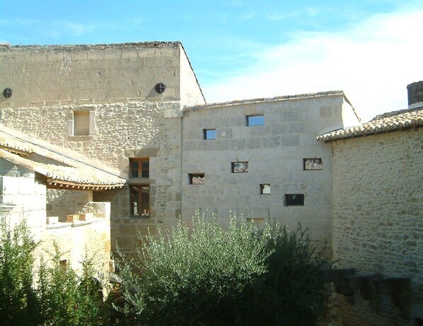 A stone building with multiple small windows and a tiled roof.