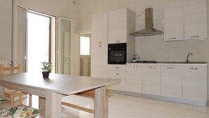 Eine moderne Küche mit weißen Schränken, einem eingebauten Backofen und einer Edelstahl-Dunstabzugshaube.