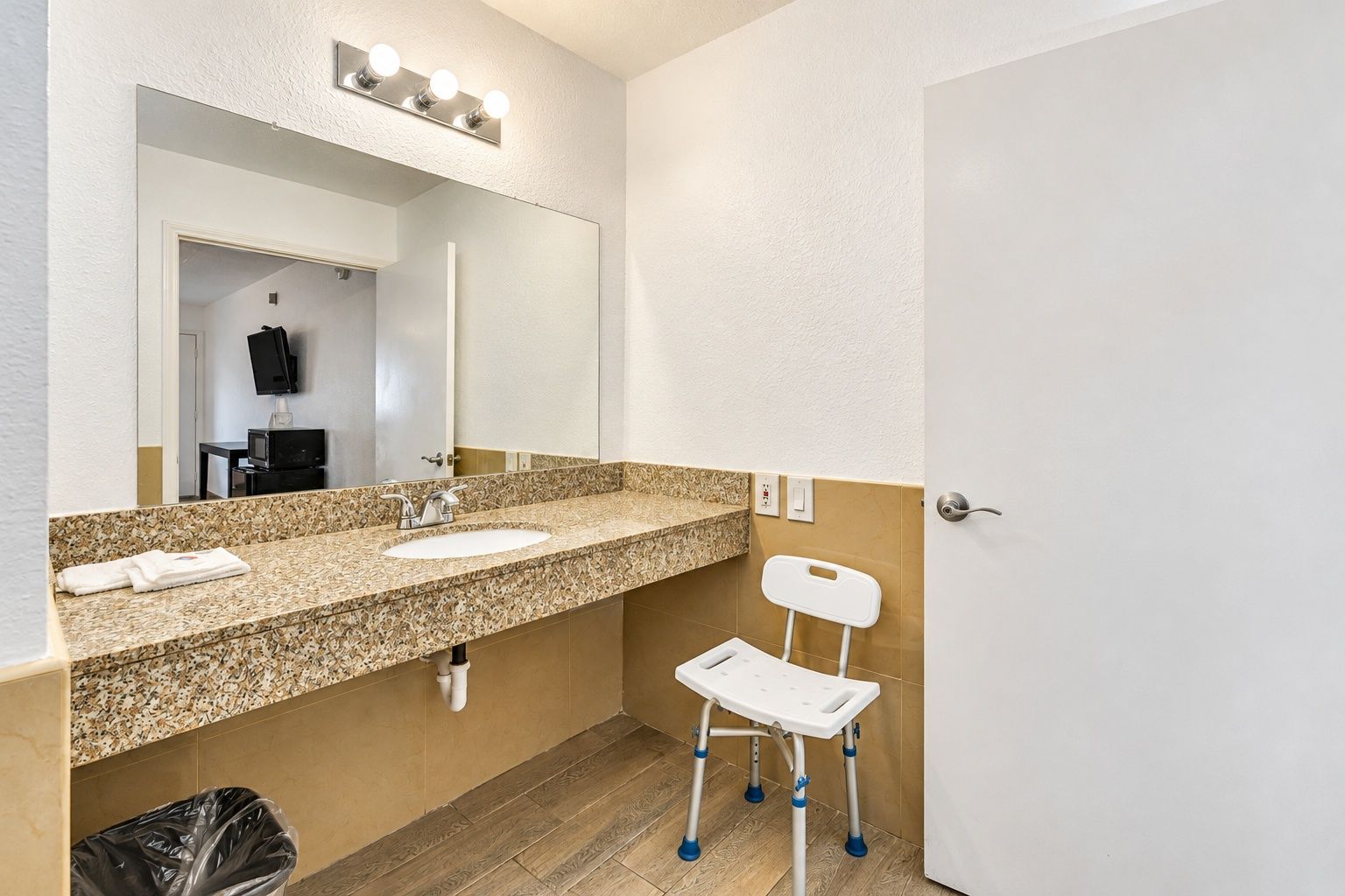 Een badkamer met een dubbele wastafel, een spiegel en een klein, wit toiletje voor kinderen.