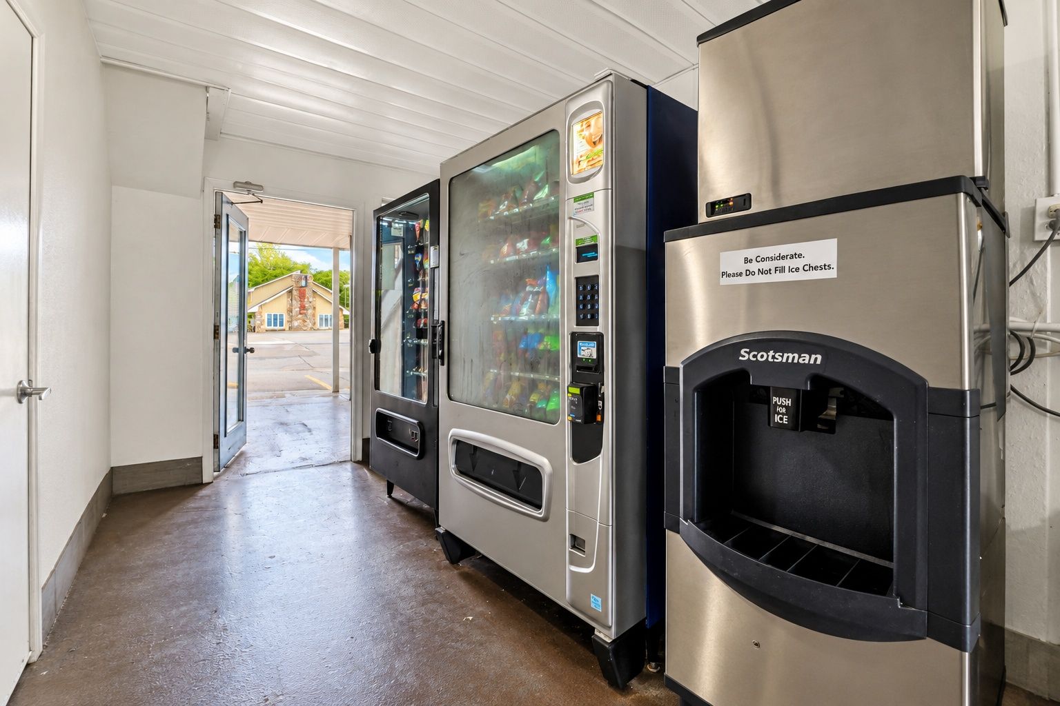 A hallway with vending machines and a Scotchman ice dispenser.
