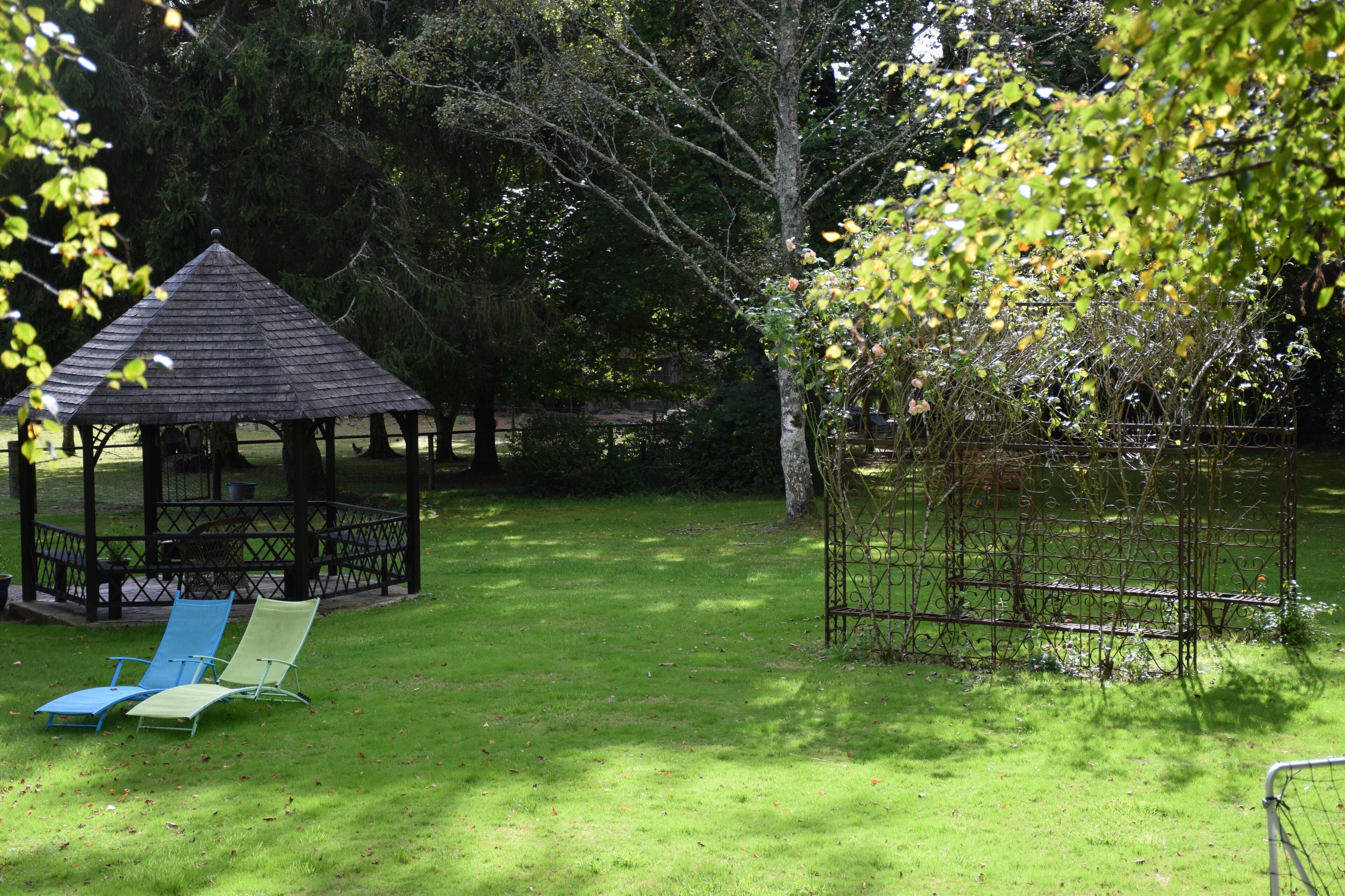 Un gazebo con tetto in metallo e un’area recintata con una panchina.