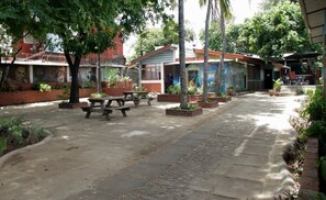 An outdoor patio area with picnic tables and potted plants. - Casa Benjamin Linder (Managua)