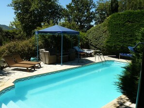 Relax and socialize by the serene pool surrounded by lush greenery and comfortable lounge chairs.