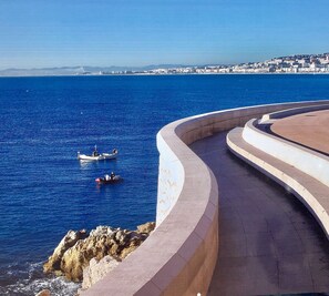 Eine Uferpromenade mit gewundener Fußgängerzone mit Blick auf das Meer.