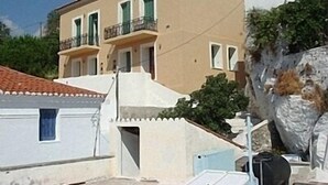 A two-story building with a flat roof and a balcony on the second floor. - Apartments In Stenies, Andros, Cyclades Islands, Greece With Panoramic Views (Andros)