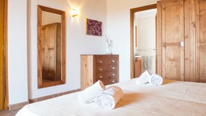 A hotel room with a large bed, wooden wardrobe, a dresser, and a mirror. - Verdal, quiet location near Portopetro, private pool, air conditioning, Wi-Fi (S'Alqueria Blanca)