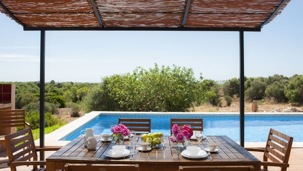 An outdoor dining area with a pool view, wooden table, chairs, and a pergola. - Verdal, quiet location near Portopetro, private pool, air conditioning, Wi-Fi (S'Alqueria Blanca)