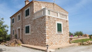 A stone building with a balcony, a staircase, and a small garden area. - Verdal, quiet location near Portopetro, private pool, air conditioning, Wi-Fi (S'Alqueria Blanca)
