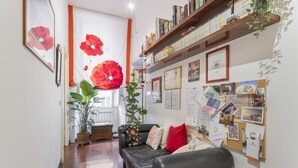 Un salon chaleureux avec un canapé en cuir, une table basse en bois et une bibliothèque remplie de livres.
