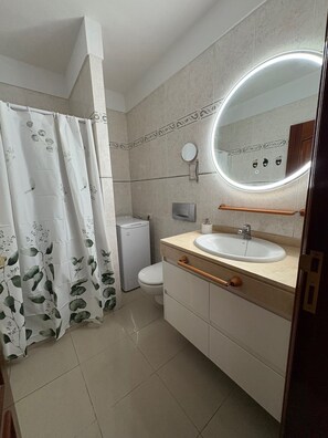A bathroom with a toilet, sink, and shower curtain. - First line beach, free WIFI, air conditioning and garage # (El Médano)