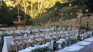 An outdoor dining area with multiple tables set for a meal, surrounded by stone walls and greenery. - Spacious Villa Noble With All the Comfort, Located In A Peaceful Location Arezzo (Arezzo)