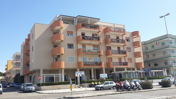 Un immeuble résidentiel à plusieurs étages, doté de balcons, d’une entrée au niveau du sol et d’une enseigne bien visible portant l’inscription « The Difference ».
