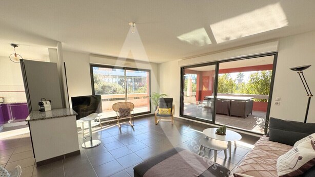 A modern apartment with a kitchen, dining area, and a large balcony with a view.