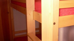 Un lit superposé avec une literie rouge.