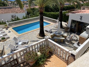 A rooftop pool area with lounge chairs, a small pool, and potted plants.