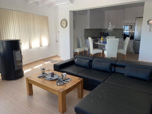 A modern living room with a black sofa, a wooden coffee table, and a TV.