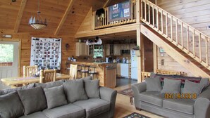 A spacious cabin with a loft bedroom, a dining area, and a kitchen.