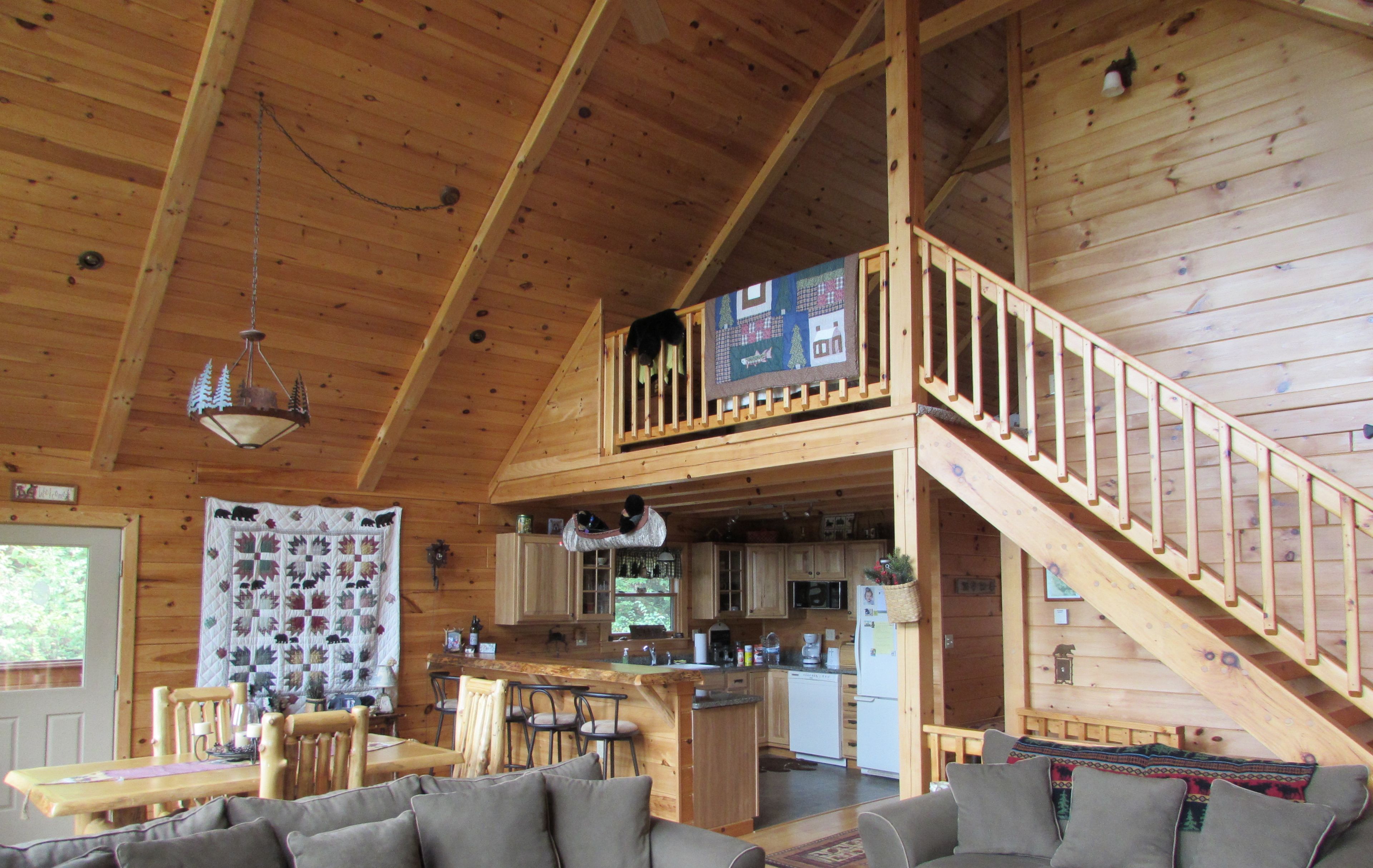 Uma cabana espaçosa com quarto no mezanino, área de jantar e cozinha.