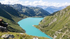 A mountainous landscape with a turquoise lake, surrounded by green hills and rocky outcrops. - Ann - SUNNY & LUXE chalet 8 pers (Haute-Nendaz)