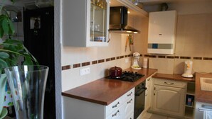 A kitchen with a stove, oven, and white cabinets. - Bed & Breakfast (Villers-Sur-Port)
