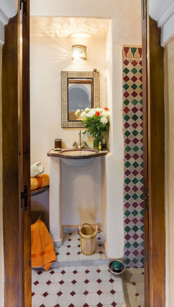 A bathroom with a sink, mirror, and decorative tiles. - Charming Riad 3 mins from Jemaa Elfna square with Marrakech Bed and Breakfast (Unknown)