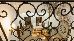 Une pièce comprenant un lit, une table et une chaise, avec un mur décoratif et un miroir.