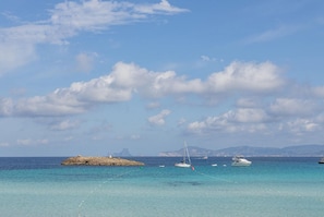 Una playa cerca, sillas reclinables de playa, toallas de playa