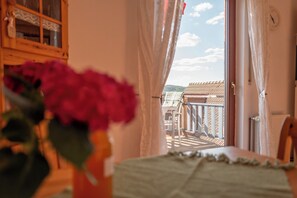 A balcony with a view of a building and a clock on the wall.