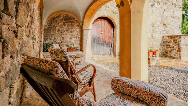 Un interior rústico de piedra con muebles de madera y arcos.