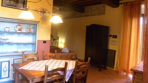 A dining area with wooden furniture, a table with a checkered tablecloth, and a chandelier. - Country Resort Rubino with shared swimming pool  (Rignano sull'Arno)