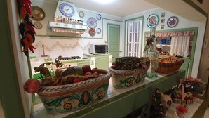 A kitchen with a microwave, a gas stove, and various decorative items. - Cyclope's House.  Amazing view and private mini SPA. (Vampolieri I)