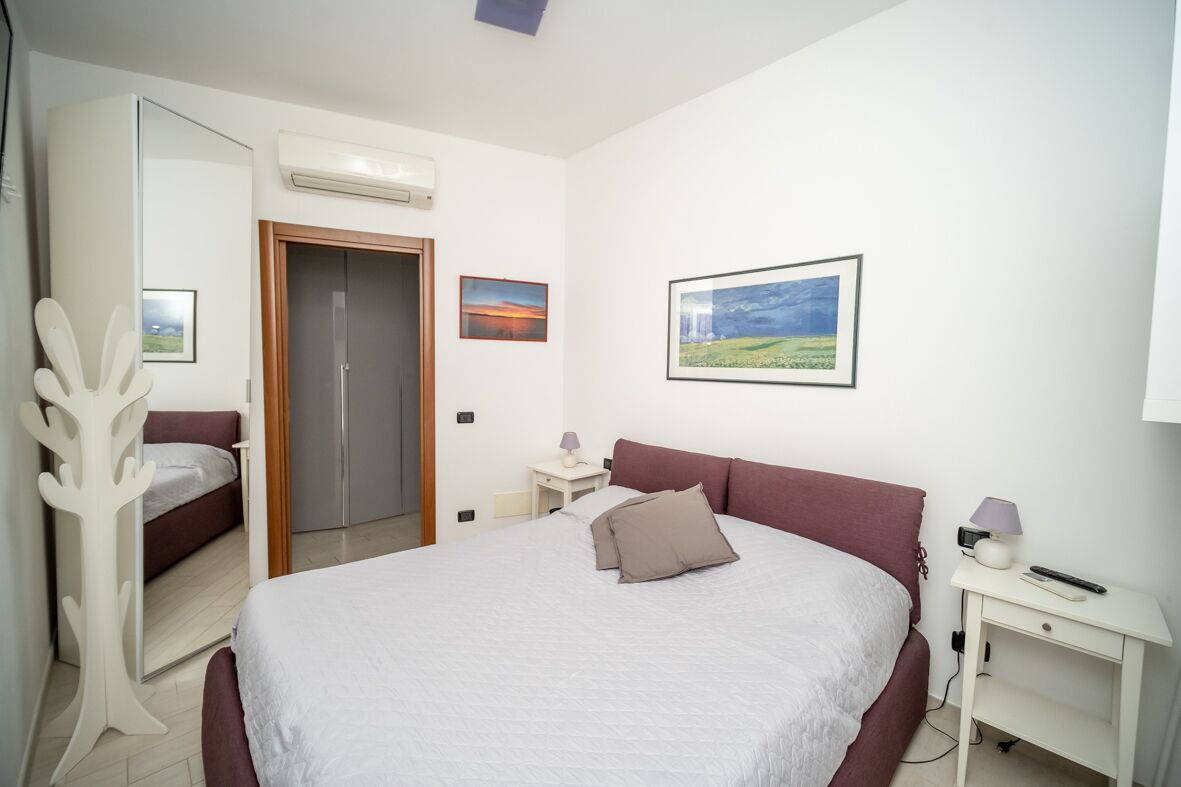 A bedroom with a bed, a wardrobe, a desk, and a chair.