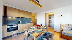 A modern kitchen with wooden cabinets, a central island, and a dining area with a bench.