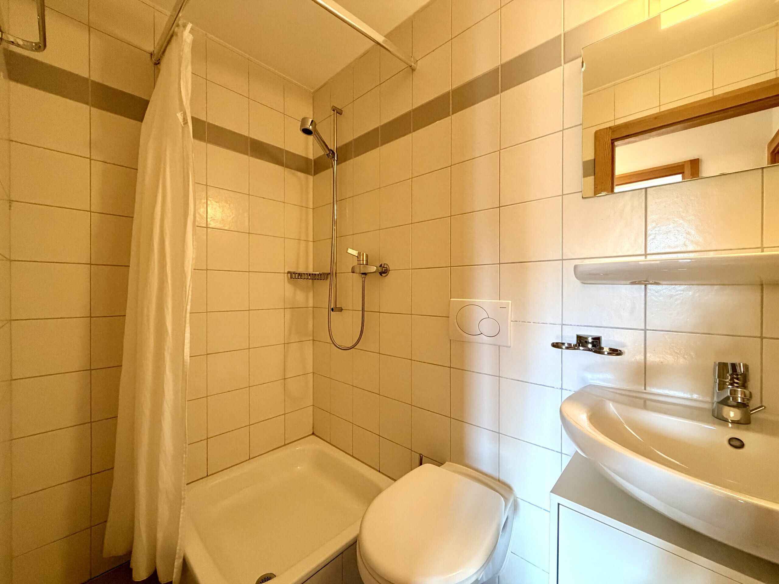 Un baño con ducha, inodoro y lavamanos.