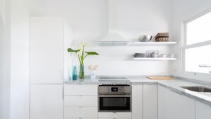 A modern kitchen with white cabinetry, a built-in oven, and a window providing natural light. - VILLA EL MATO - CASERÍO DE GUAZA (Arona)