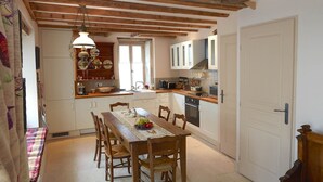 A cozy kitchen with wooden beams, a dining table set with chairs, and a bench. - Chez Hall, La Grange, 2bdr/2bth converted barn bursting with charm, Meursault (Meursault)